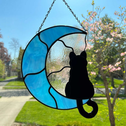 Stained Glass suncatcher of a Black cat Silhouette sitting on a light blue three quarter shaped moon.