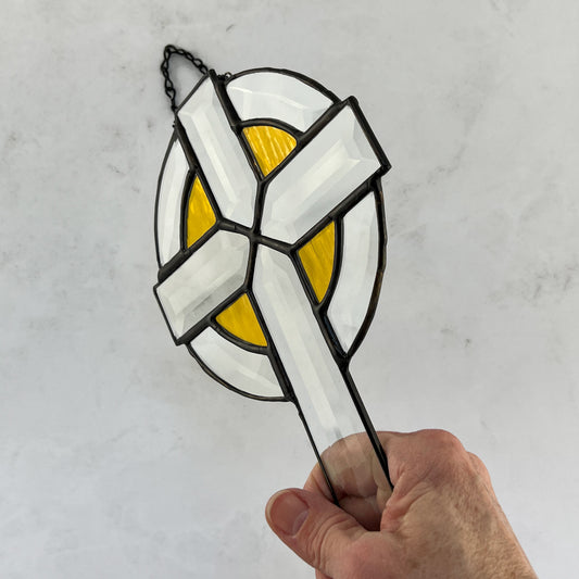 Clear beveled stained glass cross with yellow highlights around the arms of the cross  enclosed by  a clear bevel circle.  It is 9 inches by 6 inches and makes a great Easter gift for your religious friends.