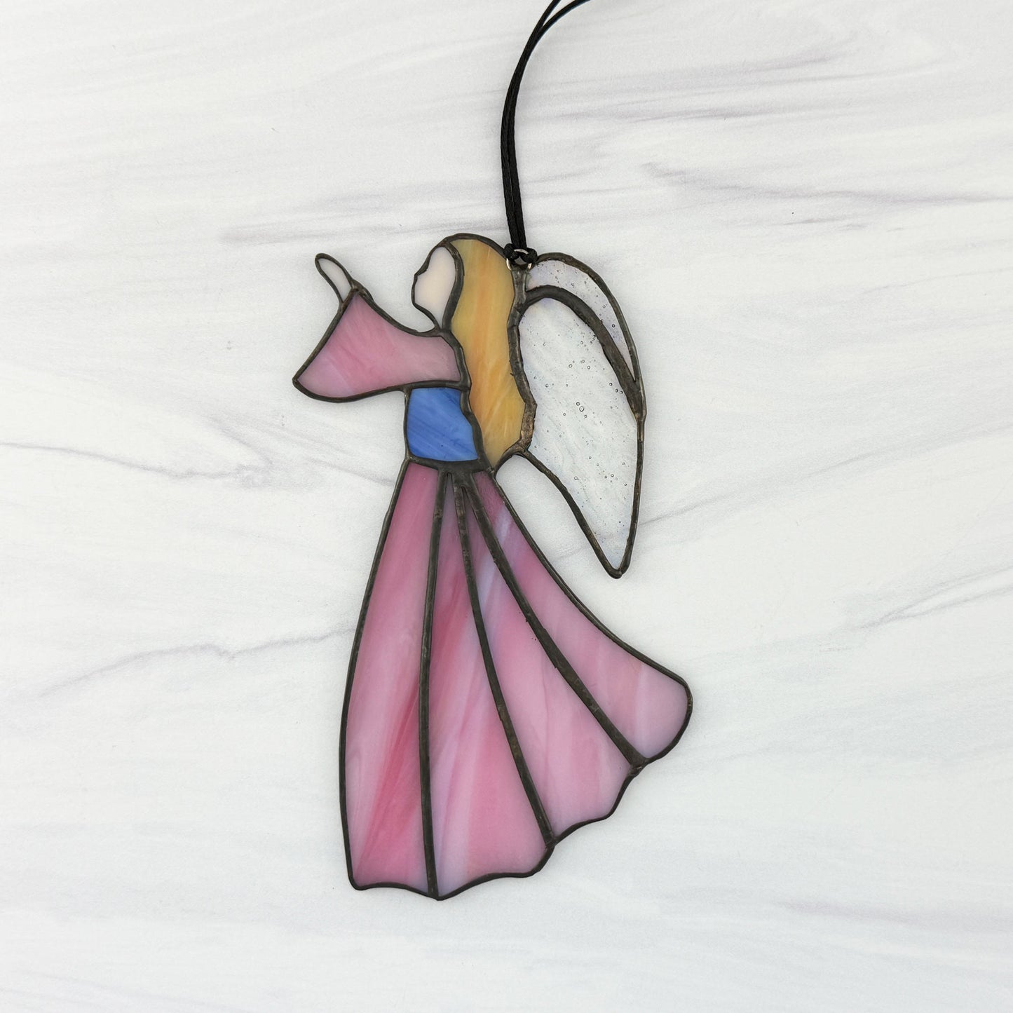 Stained glass angel ornament on a white background with a Pink dress and sleeve, Blue bodice, golden hair, and Iridescent clear wings.