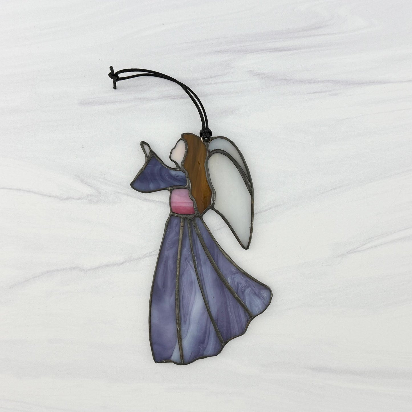 Stained glass angel ornament on a white background facing to the left.