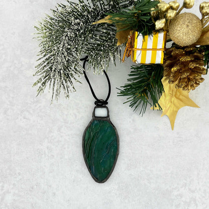 Green-Blue rippled stained glass bulb shaped Christmas ornament hung from a black cord.