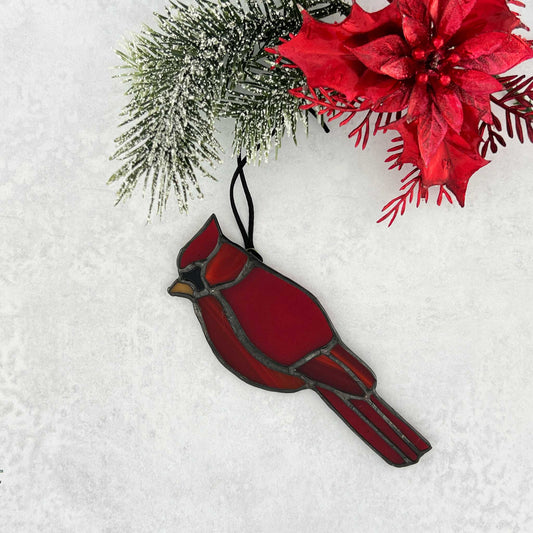 A small red stained glass cardinal bird ornament suncatcher with a black cord for hanging.