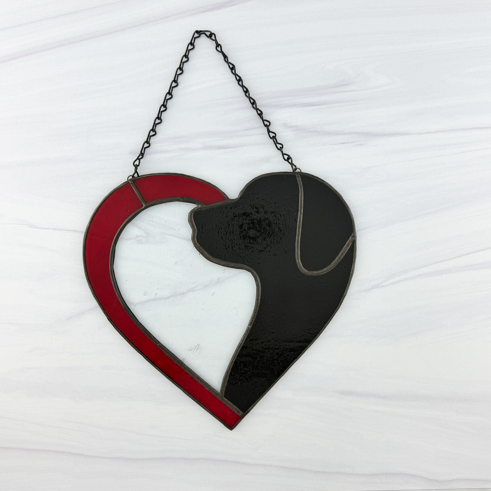 Red half-heart stained glass suncatcher with a black dog silhouette on a white background. The head is a textured black glass with smooth black glass for the ear.