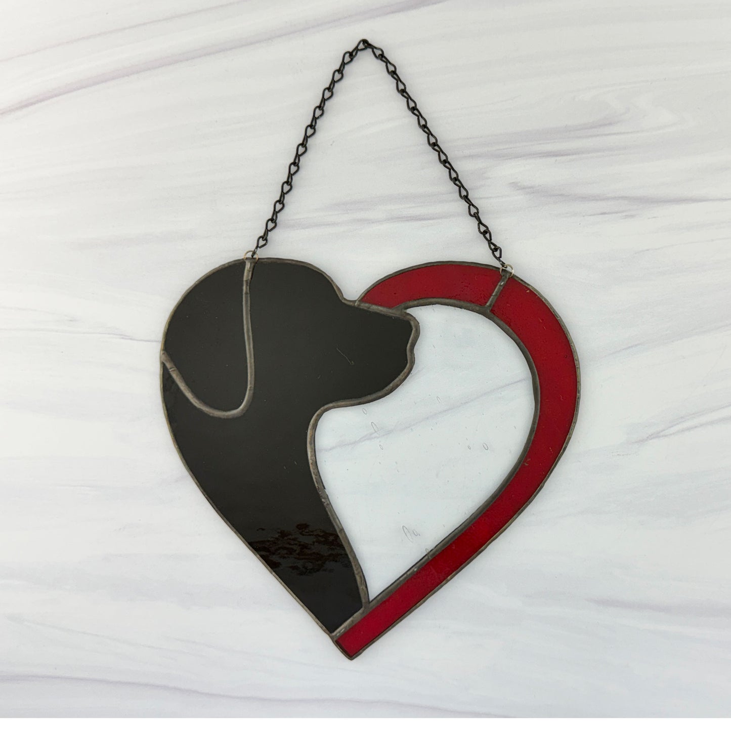 Heart-shaped decoration with black dog silhouette and red border on a white background