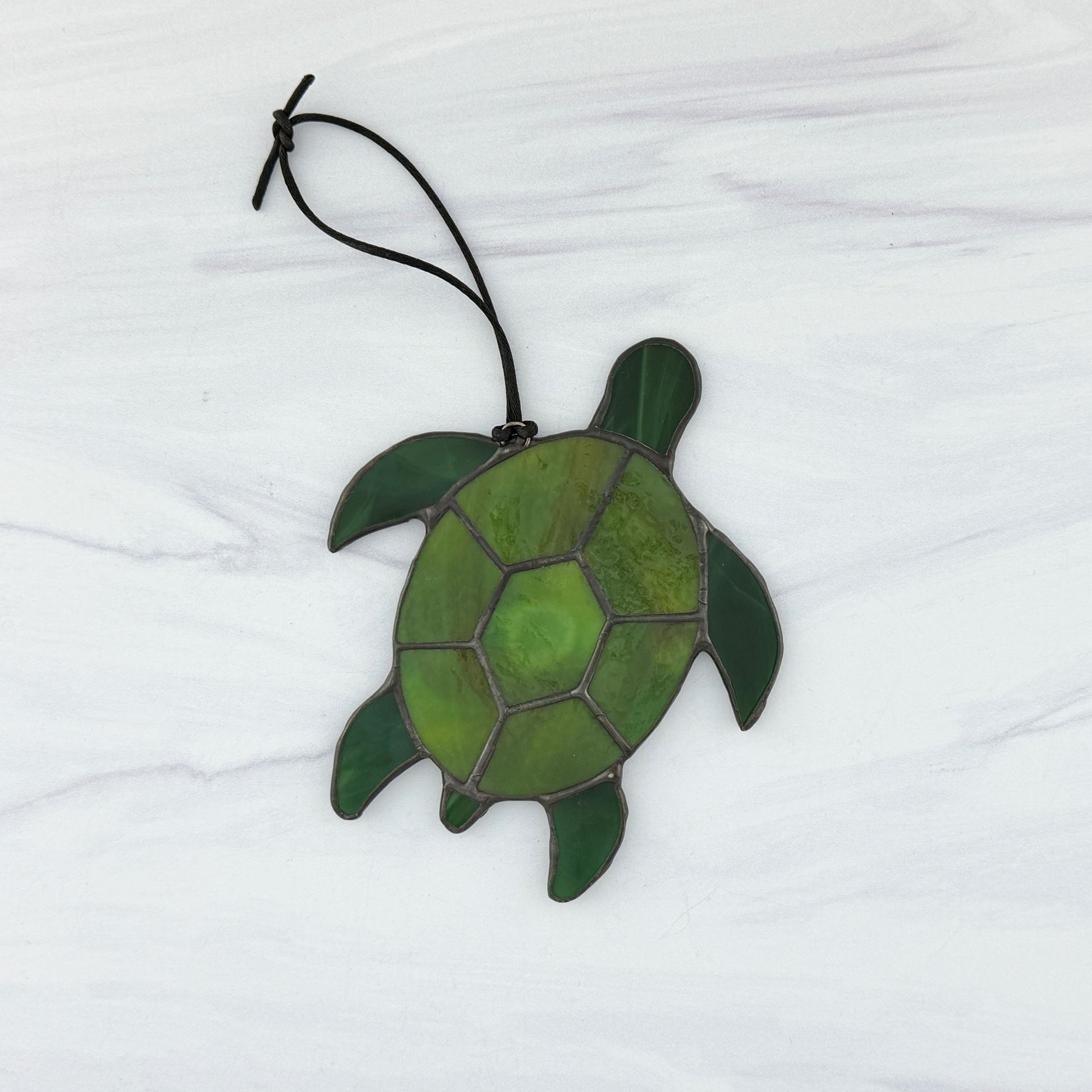 The back side of a Green stained glass turtle ornament on a white background
